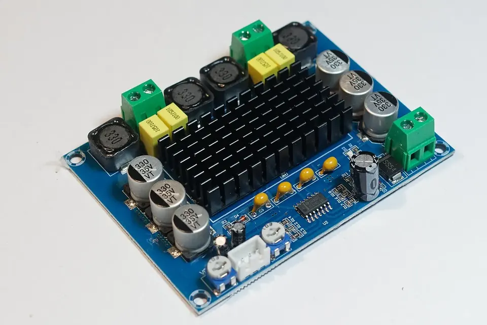 A small bare stereo amplifier circuit board with heatsink, volume knob and screw terminals