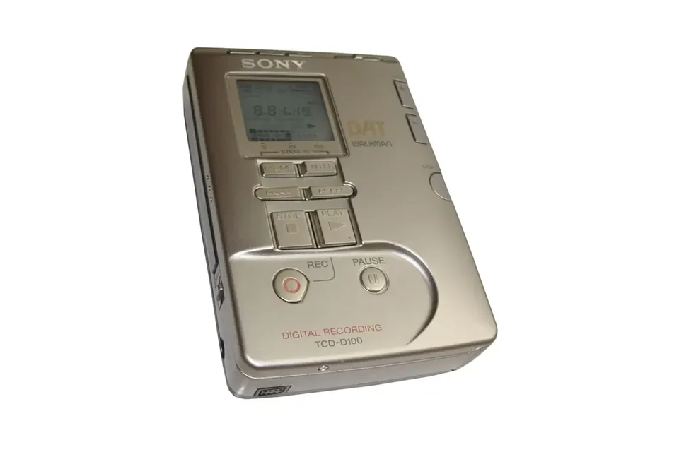A compact silver portable DAT recorder with its lid and small display