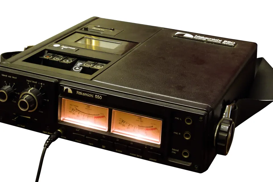 A black Nakamichi 550 portable cassette recorder from the 1970s, with two backlit level meters and a carrying strap