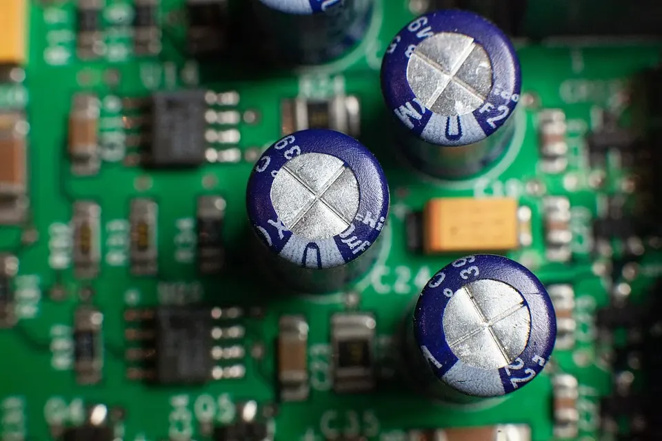 Rows of cylindrical electrolytic capacitors of different sizes mounted on a green circuit board