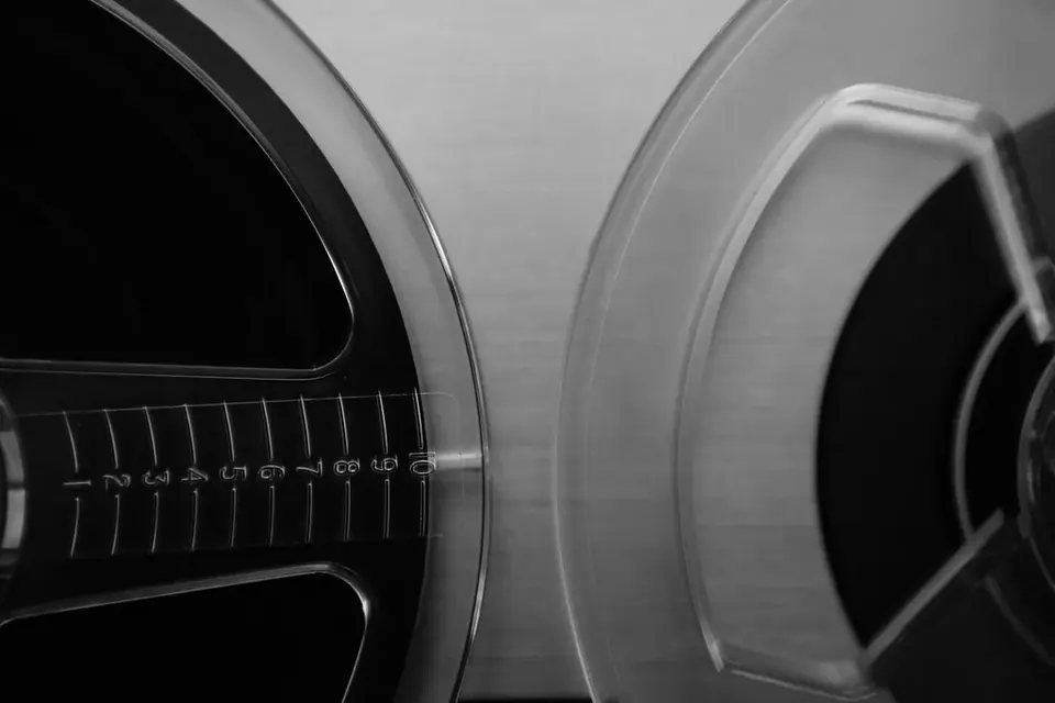 Black and white close-up of a tape reel and its transparent flange on an open-reel recorder