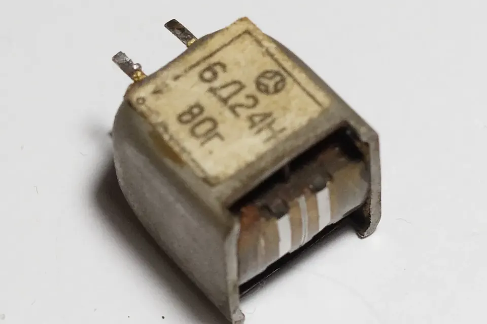 Close-up of a small, old tape head whose face has been worn deeply by the tape